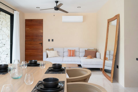Bright open living area with a cozy sofa, modern décor, and warm wood accents. Seamlessly connected to the dining space, perfect for relaxing or socializing in style.