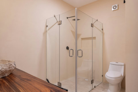 Modern bathroom with a sleek glass-enclosed shower, clean lines, and warm neutral tones. A bright and functional space designed for comfort and convenience.