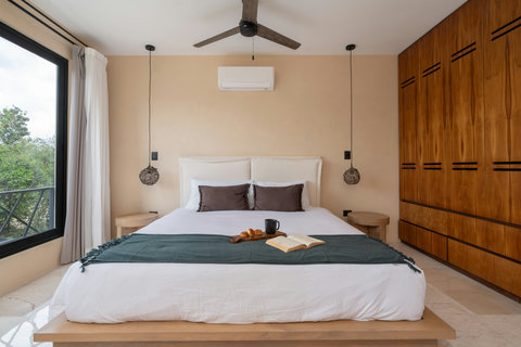Stylish bedroom with a king-size bed, warm wood accents, and soft natural light. Designed for comfort and relaxation, with elegant details and a serene atmosphere.