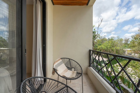 Cozy private balcony with stylish seating and peaceful jungle views. A perfect spot to relax, enjoy fresh air, and unwind in a tranquil setting.