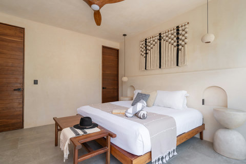 Unwind in this elegant king bedroom featuring handcrafted décor, soft neutral tones, and a calming atmosphere designed for restful tropical escapes.