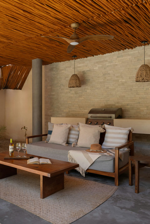Relax in a cozy open-air lounge featuring elegant tropical décor, comfortable seating, and a stylish BBQ area perfect for laid-back afternoons and evening gatherings.