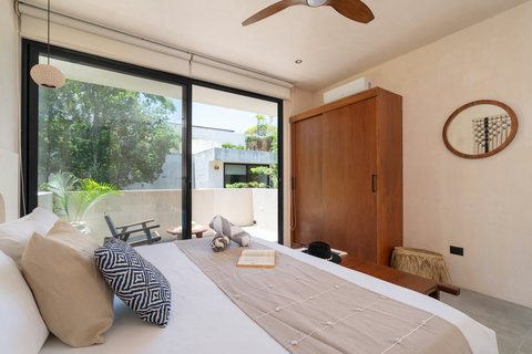 Wake up to natural light in this cozy king suite featuring warm wood accents, artisan décor, and seamless access to a peaceful private terrace.