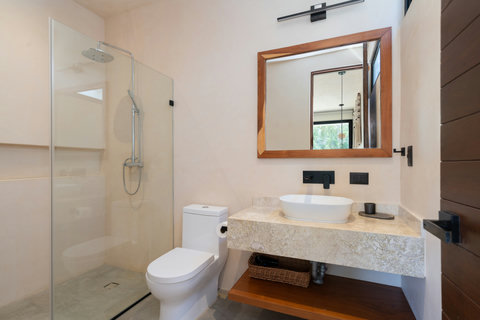 Refresh in this modern bathroom featuring a spacious walk-in rain shower, elegant stone finishes, and warm natural accents for a spa-like experience.