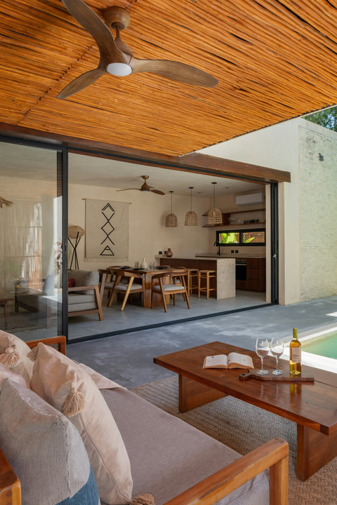 Relax in a stunning indoor-outdoor retreat featuring a private plunge pool, cozy lounge seating, and elegant tropical design with warm natural wood finishes throughout.