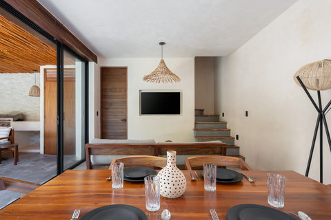 Relax in a warm and inviting living area featuring handcrafted décor, natural wood finishes, and seamless access to the outdoor lounge and private pool area.