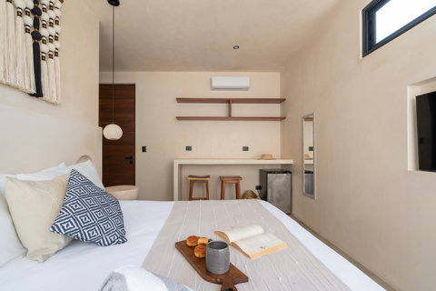Relax in this serene king bedroom featuring handcrafted décor, a Smart TV, mini fridge, and a cozy workspace designed for comfort and convenience.