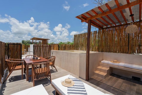 Unwind on your private rooftop terrace featuring sun loungers, an outdoor dining area, and a tranquil plunge pool perfect for relaxing under the sky.