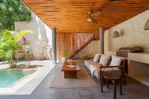 Relax in a beautiful open-air lounge featuring a private plunge pool, cozy seating, and a stylish BBQ area. Designed for laid-back tropical living and unforgettable moments.