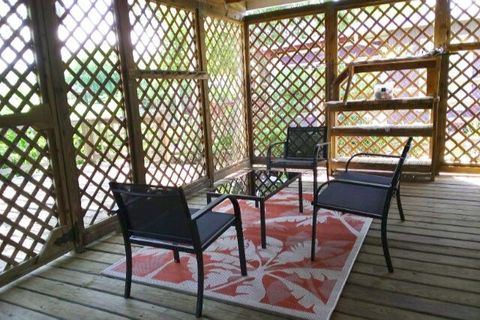 Covered Deck with Chairs and Table, Fishing Rods, Crab Nets, and Kayak
