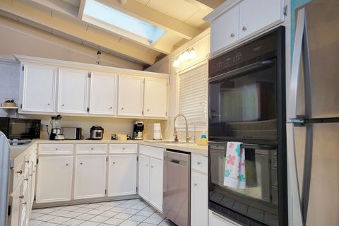 Kitchen with Refrigerator, Electric Cooktop, Two Ovens, Dishwasher, Microwave, Coffee Maker, 4-Slice Toaster, Blender, and Rice Cooker. Kitchenware, Dinnerware, Silverware, Drinking Cups, and First-Aid Kit Are Stored in the Cabinets/Drawers.