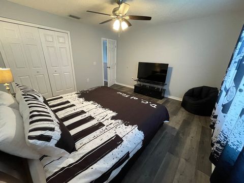 Upstairs, large, music-themed bedroom with a king bed, night stands with USB ports, and a smart TV.