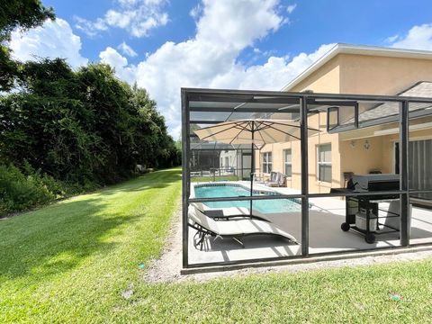 Pool lounge chairs, large umbrella, and gas grill.