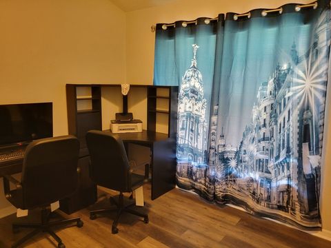Downstairs office room with computer desks, chairs, printer, TV/monitor, and a queen sofa bed.