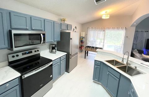 Full kitchen with stainless steel appliances and quartz countertop.