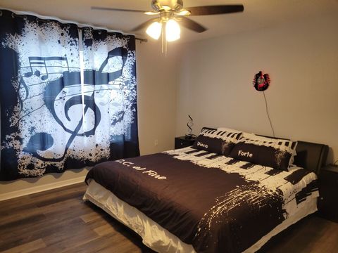 Upstairs, large, music-themed bedroom with a king bed, night stands with USB ports, and a smart TV.