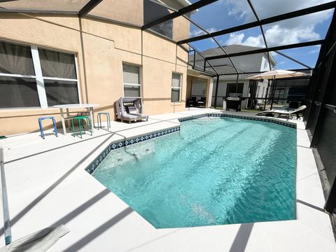 Heated pool with gas grill and outdoor furniture.