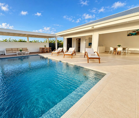 Orison — vue sur la piscine privée, la terrasse couverte et les bains de soleil disposés devant la villa.