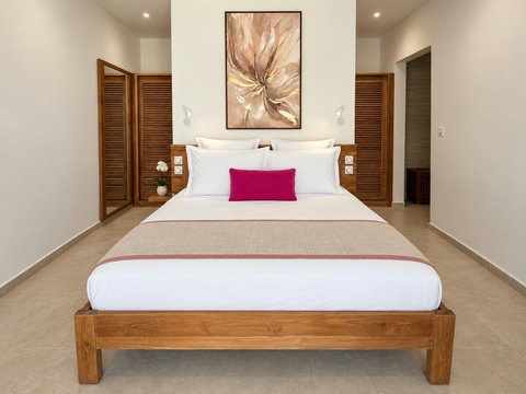 Orore — une des trois suites avec lit queen size, chevets et placards en bois.