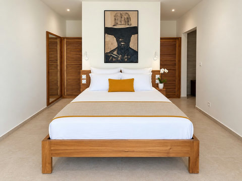 Zényte — une des trois suites avec lit queen size et placards en bois à portes persiennées.