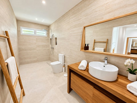 Orison — salle d’eau avec douche, vasque sur meuble en bois, grand miroir et toilettes.