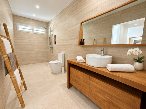 Zényte — salle d’eau avec meuble vasque, grand miroir, douche et toilettes.