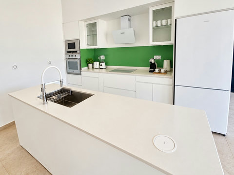 Loona — Cuisine avec îlot et évier, réfrigérateur, plaques de cuisson et four. Chaque villa du duo conserve sa propre cuisine.