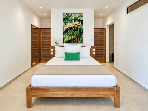 Loona — Suite 1 climatisée, avec lit queen size de 160 × 200 cm, rangements et salle d’eau privative. Le duo Loona–Orore réunit six suites au total.