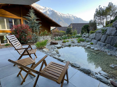 Tranquil Pondside Terrace. ️ Enjoy the magnificent Swiss Alps view from your private sitting area beside the ornamental pond and natural rock garden. A serene spot to relax, recharge, and enjoy the exclusive atmosphere.