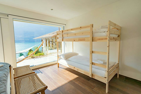 Kids' Favorite Bunk bed! Fun, comfortable bunk beds and large windows showcasing the Lake View. Direct access to the garden and hammock area makes this room a dream for children and teens. Your family's Swiss Dream Living adventure starts here!