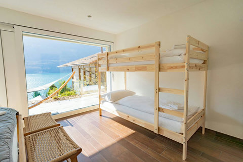 Family-Friendly Bunk Room. Fun, comfortable bunk beds right next to the massive lake view windows. Ideal for children and teens! Seamless access to the outdoor area.