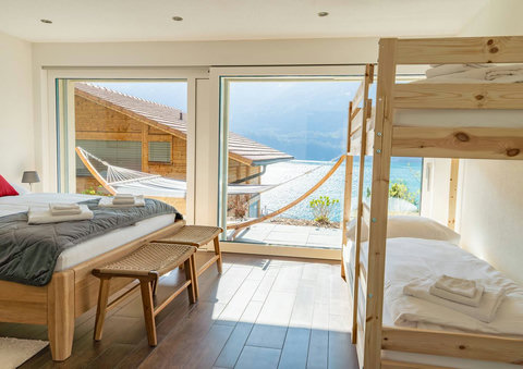 Family Fun with a View! Bright bunk room with large windows showcasing the stunning view and hammock area. Kids love this comfortable, fun space!