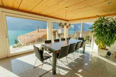 Panoramic Dining with a View! ️ Enjoy unforgettable meals around the spacious dining table, featuring breathtaking views of Lake Brienz and the Alps. Experience ultimate comfort and stunning natural light.
