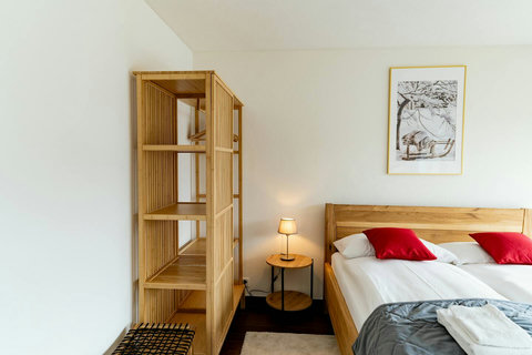 Ground Floor Comfort. ️ Peaceful and private bedroom featuring a comfortable King-sized bed and clean, minimalist Swiss design. Plenty of storage in the open wood shelving. Directly accessible from the main floor for effortless travel.