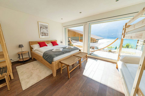 Sunlit Queen Suite. ☀️ Wake up to breathtaking Lake Brienz Views from your comfortable King-sized bed. Features floor-to-ceiling windows and ample space—the perfect private retreat
