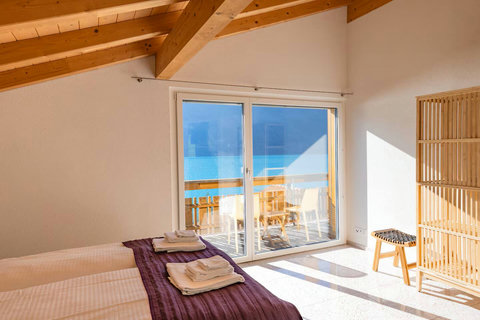 Light-Filled Attic Retreat. Panoramic views and beautiful wood beams define this cozy bedroom. Enjoy the magnificent Lake Brienz scenery from your private space.