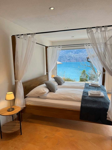 Luxury Lake View Suite.  Fall asleep in this beautiful four-poster bed with immediate, stunning views of Lake Brienz. Premium comfort for a restful Swiss Dream Living escape.