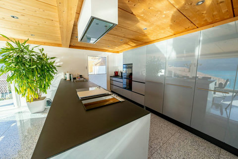 Spacious Prep Area. This large central island and expansive counter space make meal preparation effortless, even for a full group. Featuring sleek, modern, high-gloss cabinetry—a true chef's luxury from Swiss Dream Living.