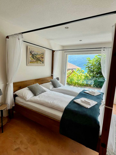 Romantic Canopy Retreat.  Fall asleep in this luxury four-poster bed with sheer drapery and wake up to the stunning Lake Brienz View. Features high-quality linens, custom artwork, and direct access to the garden terrace.