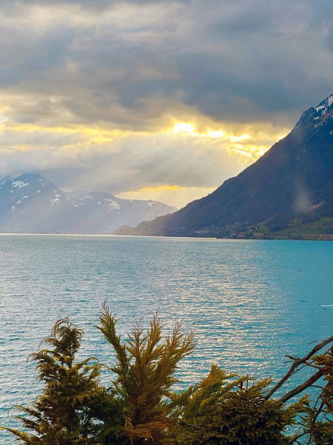 Dramatic Swiss Majesty! ☀️ Witness the breathtaking sight of light breaking over the Swiss Alps and the stunning turquoise Lake Brienz. An exclusive, ever-changing panorama that defines the Swiss Dream Living experience.