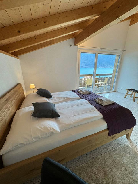 Cozy Corner Suite. Comfortable bedding under the unique angle of the vaulted ceiling. Wake up fully rested for your day exploring the Jungfrau Region.
