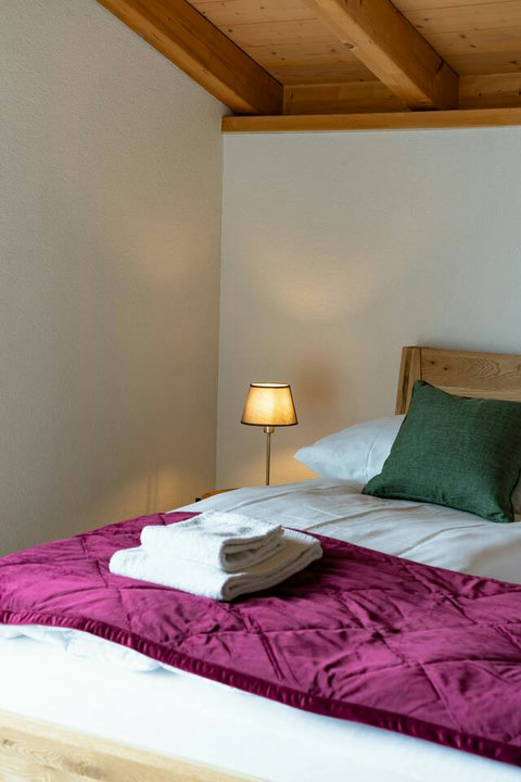 Designed for Deep Sleep.  Enjoy premium linens, plush bedding, and fresh towels under the cozy, exposed wood beams of the attic ceiling. Every detail ensures a restful night's sleep in your private Swiss Dream Living suite.