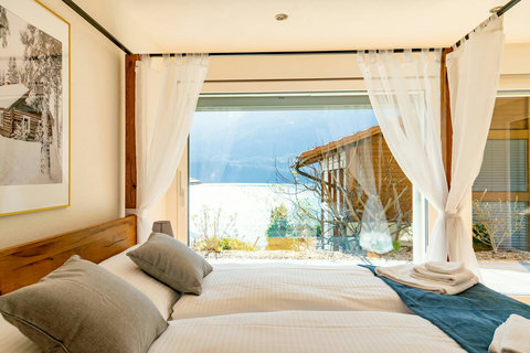 Bedroom featuring a luxurious king-sized canopy bed, stunning window views, and a full-length standing mirror, blending comfort with elegance