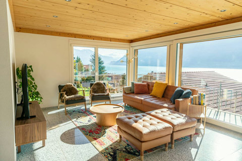 Immerse yourself in the Swiss Dream Living experience! This sun-drenched living room offers panoramic Lake Brienz views and a cozy space to relax after exploring the Swiss Alps. Perfect for creating lasting memories. Don't let this view pass you by!