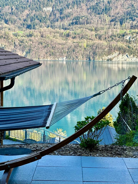 Absolute Serenity. ‍♀️ Find your perfect moment of peace in the hammock, gazing at the glassy, mirror-like reflection on Lake Brienz. Surrounded by the tranquil Swiss Alps and nature, this is the definition of a relaxing, exclusive retreat.