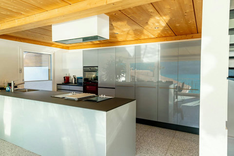 Fully Equipped Modern Kitchen. Sleek, high-gloss cabinetry and professional-grade appliances ensure effortless gourmet cooking. The spacious island and ample storage make this chef-ready space a hallmark of Swiss Dream Living design.