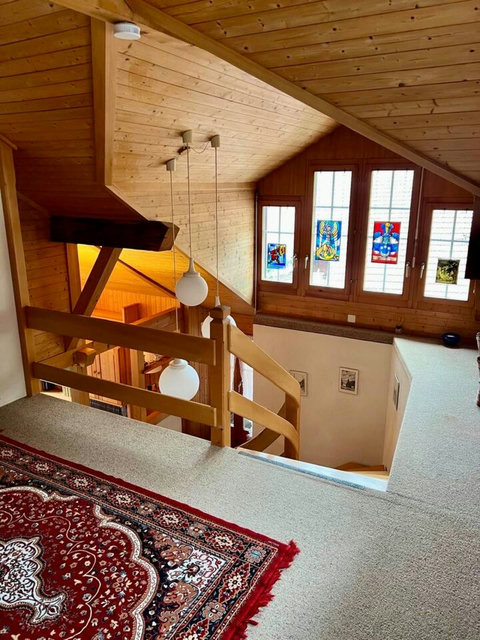 Bright wooden staircase with charming stained-glass windows.