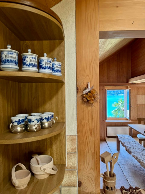 Neat kitchen shelf with decorative jars in a warm, wooden kitchen.
