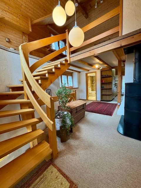 Cozy alpine living room with fireplace & handcrafted wooden staircase