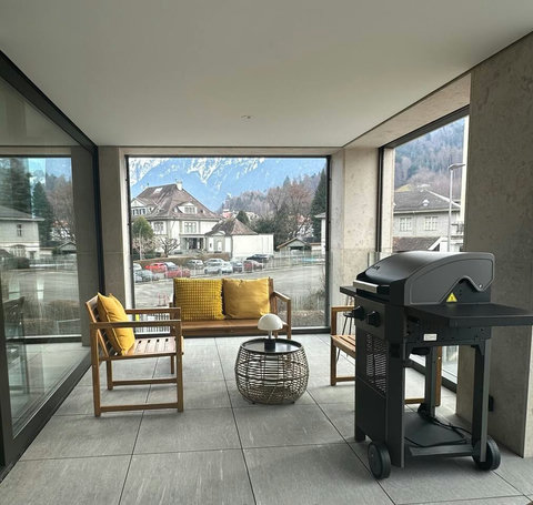 Private covered balcony with BBQ and mountain views—perfect for relaxed mornings, sunset drinks, and cozy evenings.